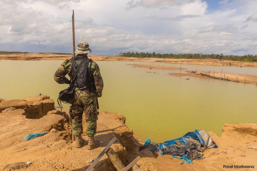 Oficial de la PNP observa una área degradada por la minería ilegal. Fuente: Pavel Martiarena