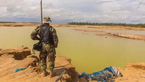 Oficial de la PNP observa una área degradada por la minería ilegal. Fuente: Pavel Martiarena